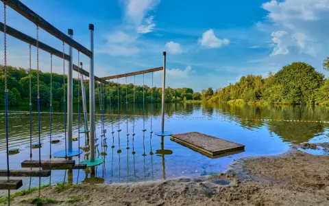 Borken am See: Ein Hindernisparcours im Wasser lädt zum Spielen ein. Der Sandstrand und die grüne Uferkulisse versprechen einen schönen Sommertag.