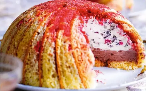 Un delizioso dolce, simile ai dolci tipici toscani, con strati di gelato al cioccolato e crema, ricoperto da savoiardi e spolverato di rosso.
