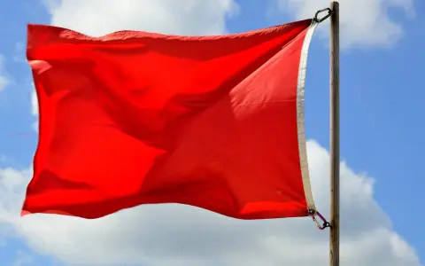 Czerwona flaga nad morzem: Co oznacza? Nie ryzykuj życia i mandatu!