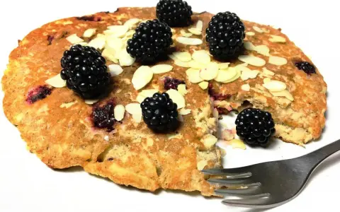 Omlet z jabłkiem i jeżynami, posypany płatkami migdałów. Pyszne śniadanie czeka na widelca.