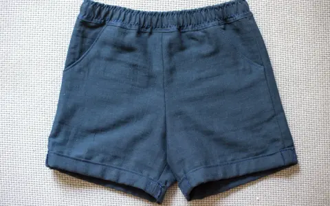 Mörkblå sy shorts med resår i midjan och fickor. Perfekta för lek och äventyr.