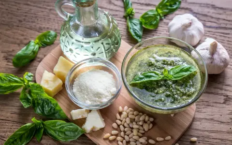 Składniki do przygotowania pesto: świeża bazylia, orzeszki piniowe, czosnek, parmezan, oliwa.