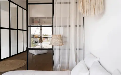 Verre et rideaux pour séparer une petite chambre en deux, créant des espaces distincts et lumineux.