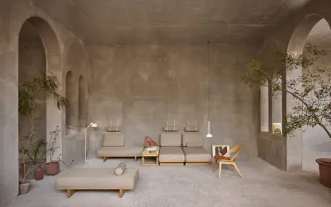 Arredamento minimalista con divani componibili e poltrona in legno. I mobili in materico significato evocano un senso di calma e naturalezza.