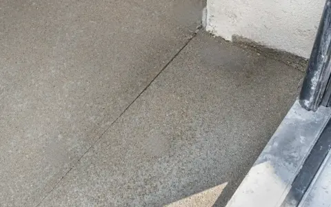 Szara posadzka betonowa z widocznym nacięciem, które zapobiega pękaniu. To właśnie jest dylatacja, która pozwala materiałowi pracować.