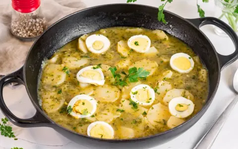 Patatas en salsa verde con huevos duros, un plato reconfortante y lleno de sabor, listo para disfrutar.