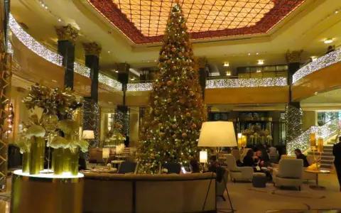 Elegancka wigilia w hotelu. Ogromna choinka i złote dekoracje tworzą świąteczną atmosferę.