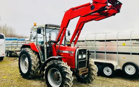 Czerwony ciągnik Massey Ferguson 390 z ładowaczem czołowym, gotowy do pracy. Dane techniczne tego modelu są imponujące.