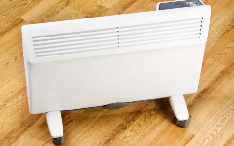 Biały, nowoczesny grzejnik elektryczny na kółkach, idealny do ogrzewania domu. Sprawdź nasz energooszczędne grzejniki elektryczne ranking!