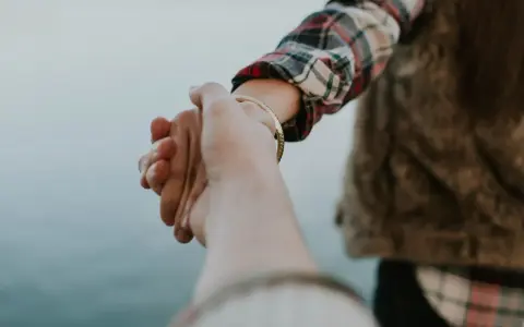 Dwie dłonie splatają się, symbolizując więź. Czy to początek czegoś nowego, czy może odpowiedź na pytanie: separacja co to?