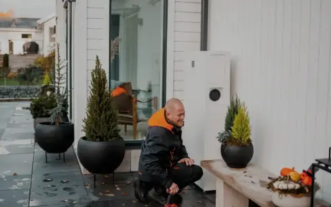Tekniker arbetar med en värmepump, en del av ett eco kraft-system för ett modernt hem.