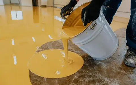 Wylewanie żółtej żywicy na podłogę. Sprawdź, jaka jest podłoga z żywicy cena za metr.