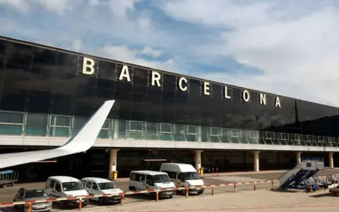 Terminal Barcelona El Prat. Samoloty, busy vans and cars waiting for passengers.