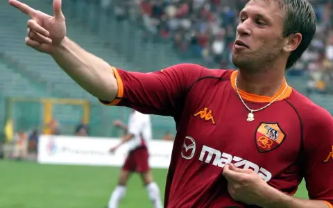 Antonio Cassano w koszulce Romy, z palcem wskazującym w górę, celebruje bramkę.