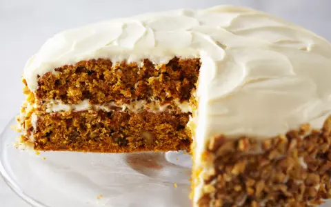 Tarta de zanahoria y queso con glaseado cremoso y nueces picadas en los bordes. ¡Un postre irresistible!