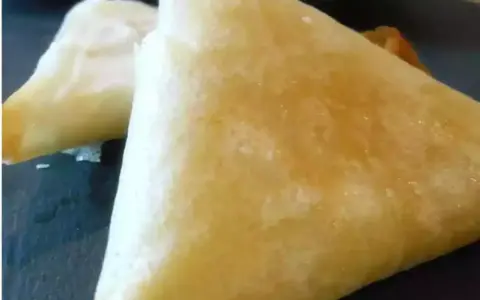 Deux samoussas dorés, un délice croustillant de brick chevre miel, prêts à être dégustés.