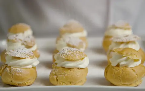 Petits choux garnis de crème fouettée, saupoudrés de sucre glace. La recette parfaite pour un dessert digne du Meilleur Pâtissier.