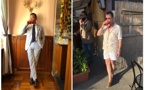 A man in a light-colored Havana suit sips a drink. Another man smokes a cigar.
