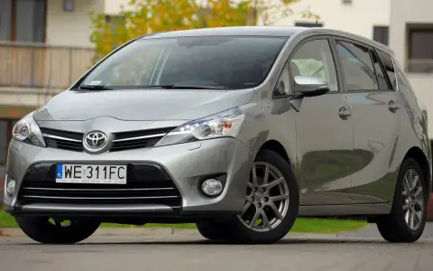 Srebrna Toyota Verso 1.8 benzyna zaparkowana przed domem.