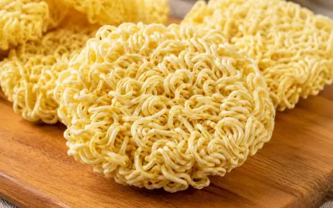 Suszone kluski do ramen na drewnianej desce. Idealne do szybkiego przygotowania pysznego dania.