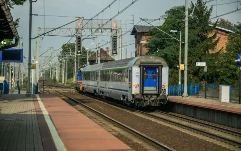 Pociąg Polregio z wygodnymi miejscami siedzącymi stoi na peronie.