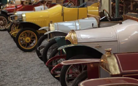 Reihe von Oldtimern, von denen jeder einen hohen schlumpf autosammlung wert hat. Gelb, weiß und rot sind die dominanten Farben.