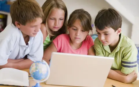 Dzieci uczą się, jak sprawdzić swoją lokalizację na mapie świata, korzystając z laptopa.