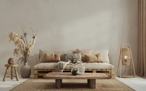 Un divano in pallet e un tavolino grezzo creano un'atmosfera rilassata in stile wabi sabi, con cuscini morbidi e decorazioni naturali.