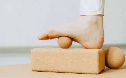 Fuß mit Ball auf Korkblock für Plantarfasziitis Dehnen.