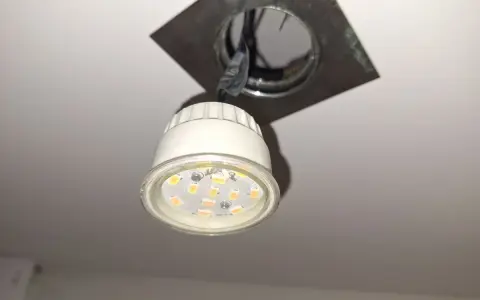 Wymiana żarówki led w oprawie sufitowej. Nowa, energooszczędna żarówka czeka na montaż.