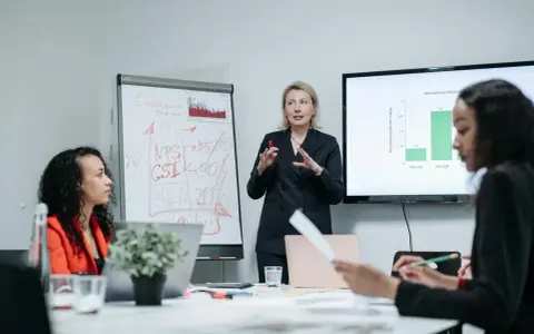 Zespół omawia strategię rozwoju, w tym automatyzację testów oprogramowania. Na tablicy widać KPI, NPS, CSI i SLA.