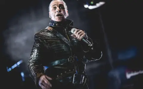 Till Lindemann w skórzanej kurtce, z mikrofonem w dłoni, jakby opowiadał historię swojej żonie.