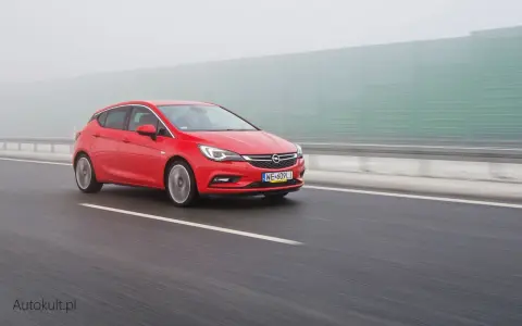 Czerwona Astra na autostradzie w mgle. Zastanawiasz się, ile pali Opel Astra? Ten model może być zaskakująco oszczędny.