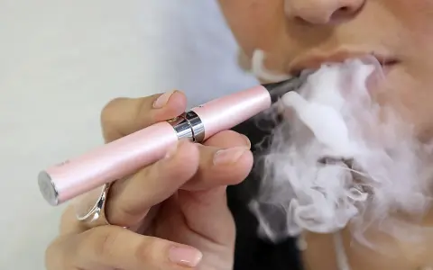 Persona usa un vapeador para dejar de fumar, exhalando una gran nube de vapor.