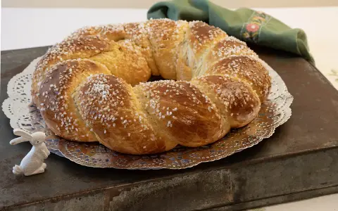 Rosca de Pascua gallega, trenzada y espolvoreada con azúcar, junto a un conejito blanco.