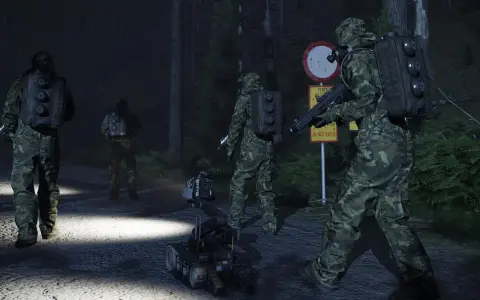 Żołnierze w kamuflażu i robot zwiadowczy na nocnej drodze leśnej.