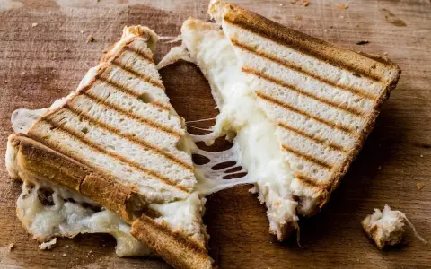 Pyszny, ciągnący się ser w tostach. Zastanawiasz się, ile kcal ma tost z serem? Ten wygląda na około 300-400 kcal.
