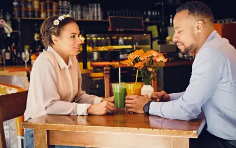 Para, która rozmawia przy stoliku, pijąc soki. W tle kawiarnia. Psychologia mężczyzny miłość w spojrzeniu.