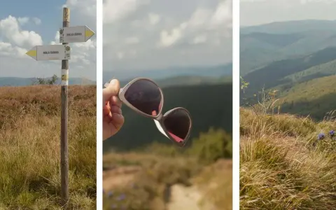 Droga na Małą Rawkę prowadzi przez trawiaste wzgórza. W tle góry, a w ręce okulary przeciwsłoneczne.