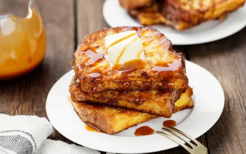 Pile de pain perdu salé doré, nappé de sirop et garni de beurre fondant. Un délice pour le petit-déjeuner.