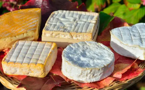 Assortiment de fromages, dont un en forme de cœur, évoquant les spécialités culinaires de Rouen.