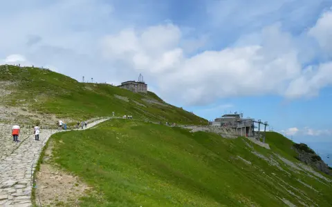 Kamienista ścieżka prowadzi na szczyt Kasprowego Wierchu. Widać tam budynki i kolej linową. Wysokość robi wrażenie!