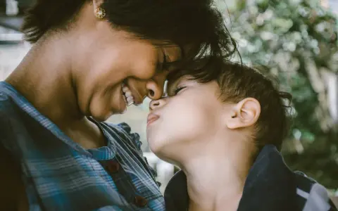 Ein inniges Lächeln verbindet Mutter und Kind. Ihre Nasen berühren sich, ein Moment purer, unendlich liebe zum Kind.