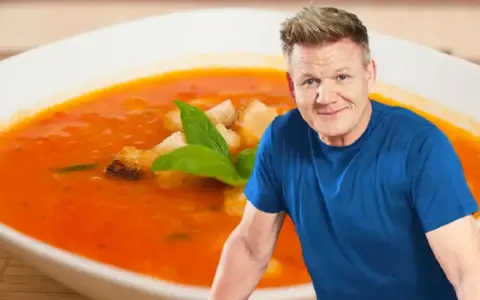 Gordon Ramsay z talerzem zupy pomidorowej. Zastanawiasz się, jakie przyprawy do zupy pomidorowej? Bazylia i grzanki dodają smaku.