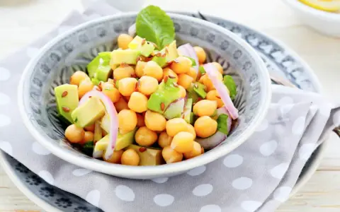 Deliciosa ensalada de garbanzos y aguacate, con cebolla morada y semillas de lino. Fresca y nutritiva.