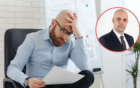Zmartwiony mężczyzna analizuje dokumenty, podczas gdy w tle widać portret biznesmena. Obraz symbolizuje analizę przyczyn bezrobocia w Polsce.