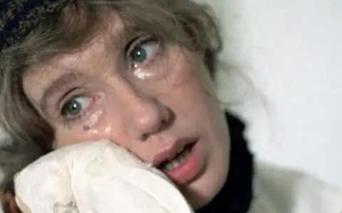 Twarz Krystyny Jandy, łzy spływają po policzkach, chusteczka przy ustach. Mają Komorowska w dramatycznej scenie.