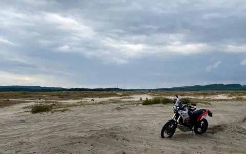 Motocykl na piaszczystym terenie, idealny na szlak Orlich Gniazd samochodem trasę.
