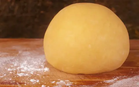 Impasto giallo dorato, pronto per diventare la base perfetta per una deliziosa pasta frolla per pastiera.