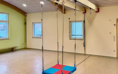 Therapieschaukel für Kinder im Test. Die Schaukel hängt von einer Deckenkonstruktion herab und ist bereit für den Einsatz.